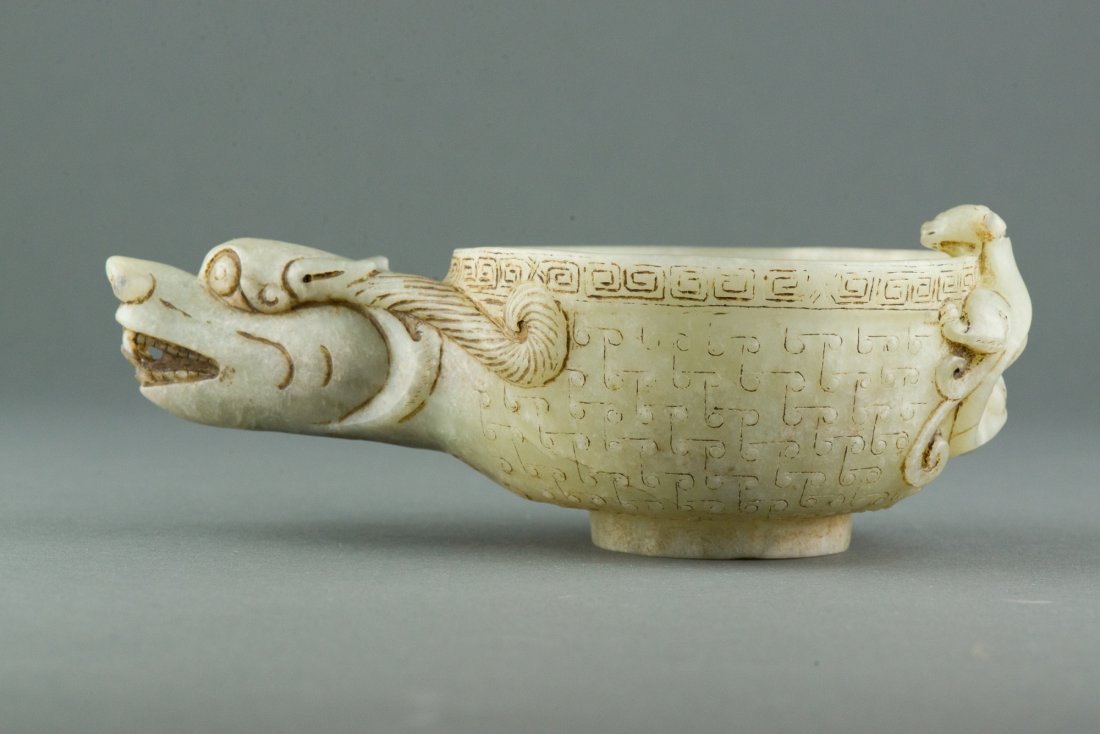 Charming Chinese Jade Cup Carved Chilong: Chinese white jade carved cup, of bell shaped cup with raised foot, flanked with large protruding Chilong head on one end and small curious Chilong clinging on another end. Cup body decorated with Chi