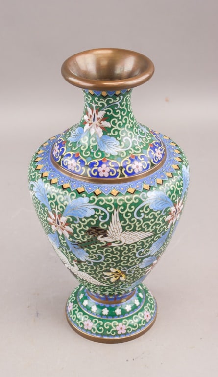 Chinese Fine Cloisonne Porcelain Vase: Chinese cloisonné enamel vase with green ground decorated with cranes in flight among floral and scroll motifs, the neck and foot with geometric borders and metal rims. H: 33 cm, Dia: 18 cm, 1,459g