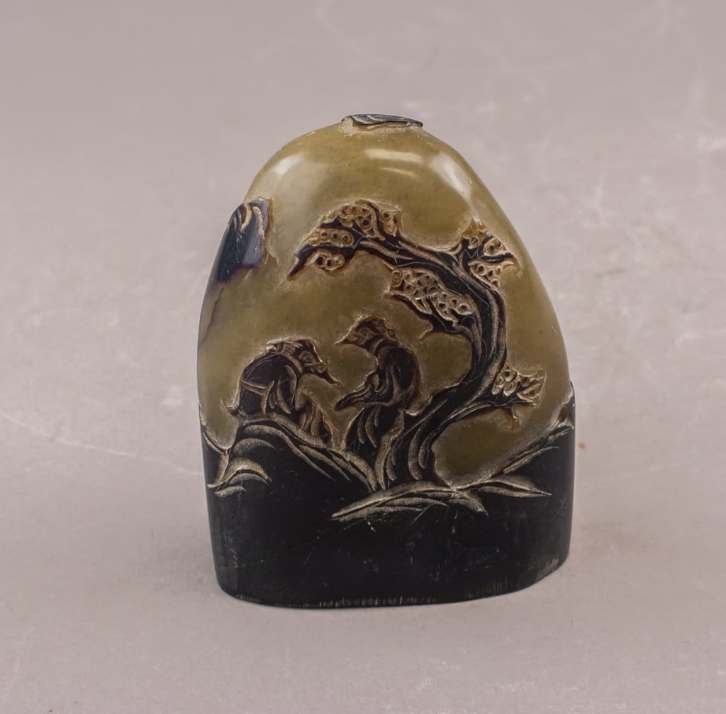 Chinese Shoushan Stone Carved Black Seal: A carved Chinese Shoushan stone seal of dark-toned material, the side finely worked in relief with two seated figures beneath a tree, showing layered ground lines and textured foliage. The stone displ