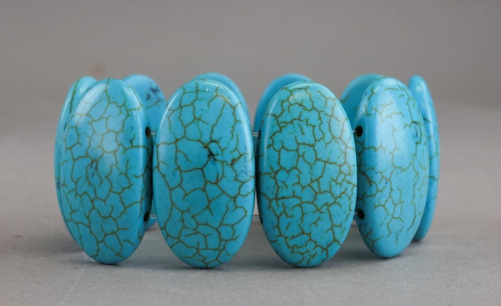 Vintage Howlite Turquoise Elastic Bracelet: Vintage howlite turquoise-style elastic bracelet composed of polished oval beads displaying blue coloration with brown veining patterns, the stones arranged in a continuous stretch band with uniform s