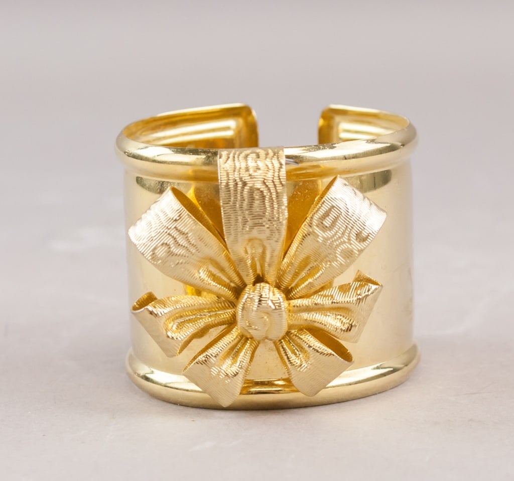 Vintage Gold-Plated Ribbon Bow Cuff Bracelet: A vintage gold-plated cuff bracelet formed as a textured ribbon bow at the front, the metal finished in a bright polished tone with an open back for wear. H: 4 cm, W: 5 cm, 45g
