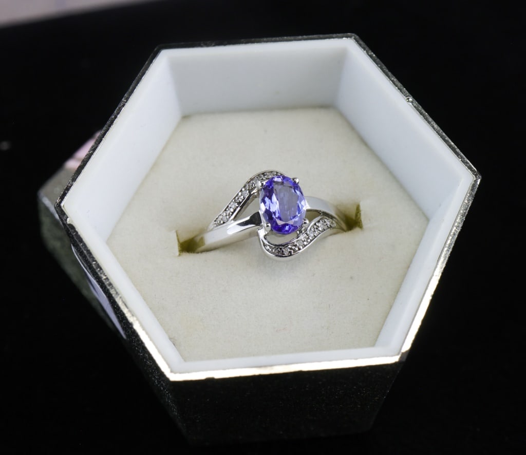 Silver-plated Tanzanite & Diamond Ring w/ GLA: Silver-plated ring set with a 1.75ct oval violet-blue tanzanite accented by round brilliant-cut diamonds totaling approximately 0.18ct, accompanied by a GLA identification card detailing gemstone meas