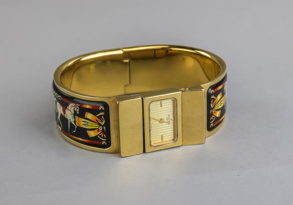 Vintage Hermès Loquet Bangle Watch: Gold-tone Hermès Loquet bangle watch with integrated rectangular dial featuring horizontal guilloché pattern and simple hour and minute hands, set within a hinged bracelet form. The exterior panels 