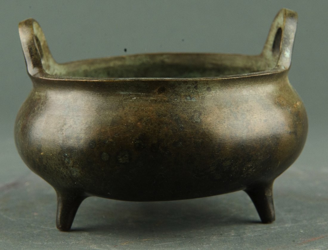 Chinese Tripod Bronze Censer w Ming Hu Bang Zuo Mk: Chinese tripod bronze censer, of squatted globular form with two ring handles. Bottom with sixteen characters Ming Xuande Hu Bang Zuo marker`s mark. H: 11.2 cm, W: 7.5 cm, 385 grams. Provenance: T. Ng