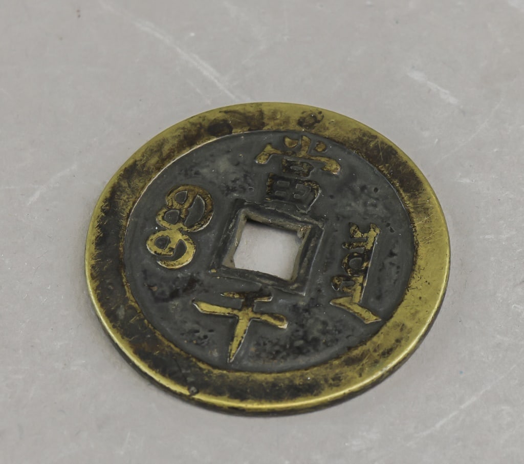 Chinese Qing Era Antique Big Coin: Chinese Qing era cast cash coin of large format with central square aperture and surrounding character inscriptions, the piece showing mixed dark and brassy tones with surface wear and oxidation