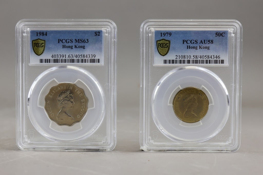 PCGS 1979 & 1984 Hong Kong Coins 2pc: PCGS-certified Hong Kong coin pair comprising a 1984 $2 graded MS63 and a 1979 50?Cents graded AU58, each housed in its respective encapsulated holder with full label details, both pieces showing