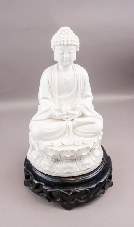 Chinese Fine Blanc de Chine Porcelain Buddha: Chinese Blanc de Chine porcelain figure of a seated Buddha shown in a meditative pose on a lotus pedestal, modelled with a serene expression, detailed robe folds, and a chest symbol, the hands positio
