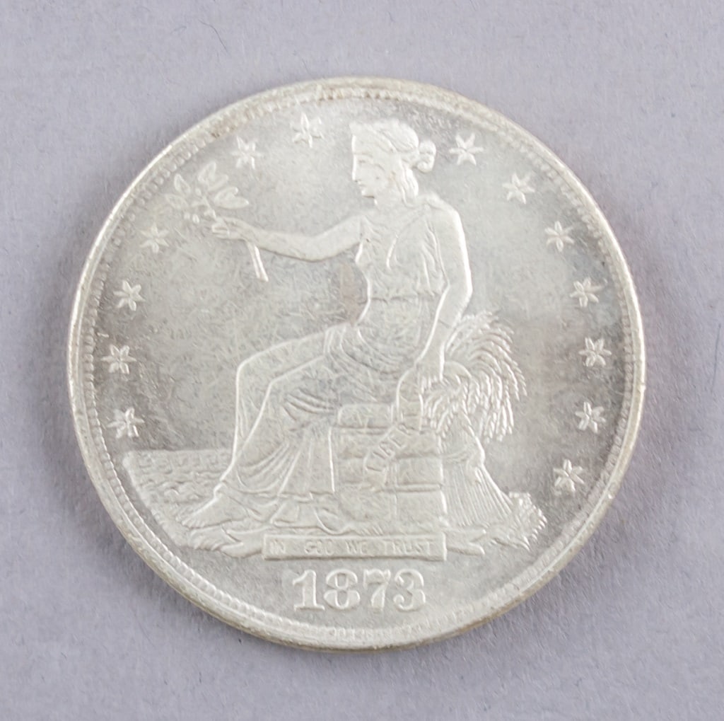 1873 American Trade Dollar Coin: 1873 American Trade Dollar coin, a first-year U.S. issue featuring Seated Liberty with olive branch and wheat bundle motifs framed by thirteen stars. Dia: 3.5 cm, 26.68g, Density: 8.29