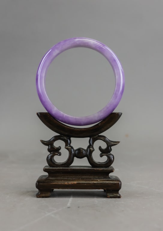 Chinese Purple Jadeite Carved Bangle: Chinese purple jadeite bangle of circular form, carved and polished to a smooth uniform profile with light-to-medium lavender coloration and natural tonal variation, the material showing consistent tr