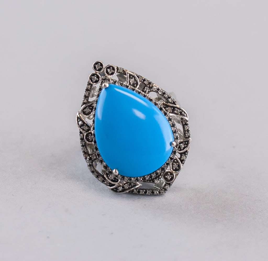 Chinese sterling silver ring tourquise: Pear-shaped turquoise stone sterling silver ring featuring a large polished blue cabochon framed by an ornate beaded and dark-accented surround, the split-shank band and setting showing bright silver 