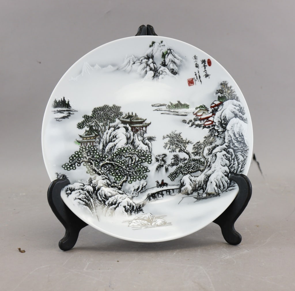 Chinese White Porcelain Plate Huairen Hall Mark: A Chinese white-porcelain plate finely painted with a winter landscape of mountains, trees, pagodas, and a lone figure crossing a bridge, accompanied by calligraphy and red seals, and bearing a Huaire