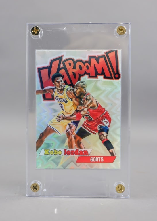 Kobe & Jordan Kaboom GOATS Facsimile Auto Card: A modern dual-player collectible card featuring comic-style artwork of Kobe Bryant and Michael Jordan, set against a bold ?KABOOM!? background, with printed facsimile signatures, numbering text at low