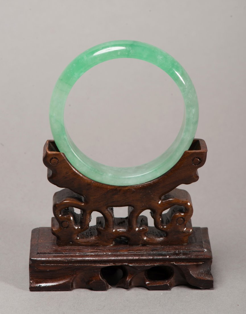 Chinese Translucent Green Jadeite Bangle: Chinese circular jadeite bangle, of translucent apple green tone, semi-rounded edge. Wooden stand not included. D: 7 cm, inner D: 5.5 cm, 52 grams.