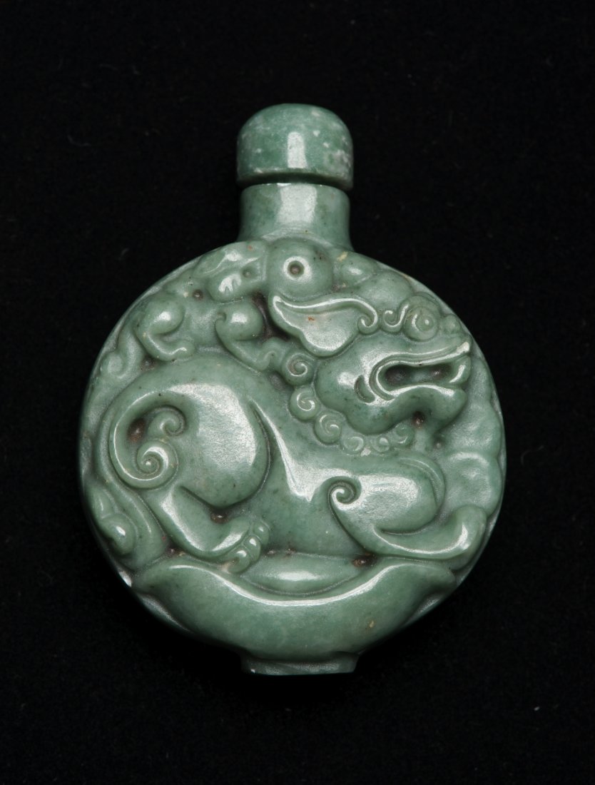 Chinese Green Hardstone Fu Lion Snuff Bottle: Of flattened flask form, finely carved a Fu lion with cub on its back. H: 7 cm, W: 5 cm, 92 grams. Provenance: T. Ng Collection Toronto.
