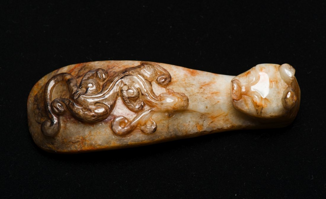 Chinese Old Jade Carved Chilong Belt Buckle: Chinese old jade carved belt buckle featuring head of a mythical beast and a sinuous Chilong, the stone of white with brown rivering. H: 2 cm, D: 10 cm, 98 grams. Provenance: T. Ng Collection Toronto.
