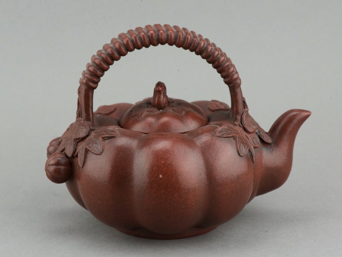 Chinese Pumpkin Form Zisha Teapot SIgned: Chinese Zisha teapot, modeled as a pumpkin shape, decorated with upward coil handle, bottom and under lid stamped artist seals. H: 12 cm, W: 15 cm, 405 grams.