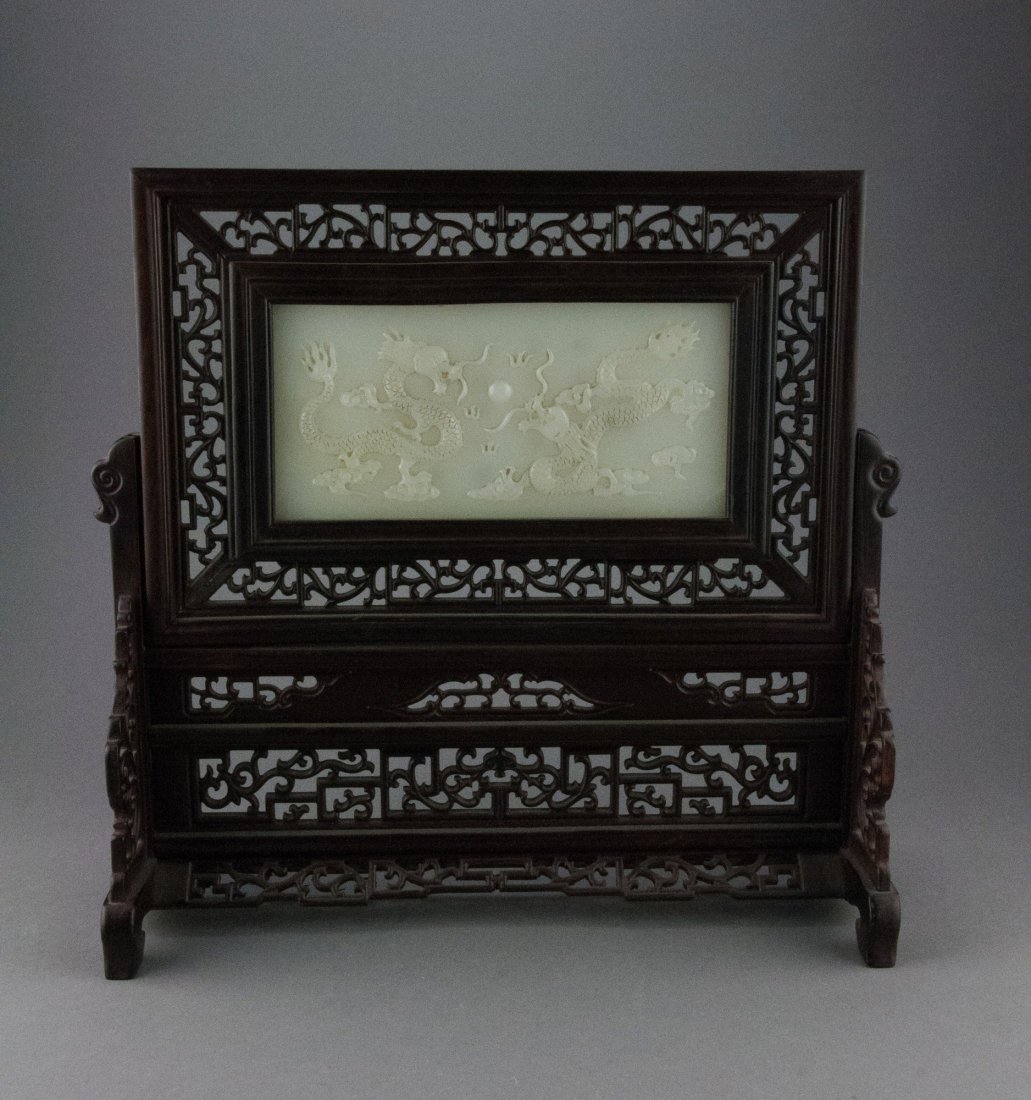 Chinese Rosewood Table Screen w/ Hardstone Inset: Mounted in open work Rosewood frame, the white hardstone finely carved with pair of dragons pursuing flaming pearl on front with Chinese gold scripts on verso, sealed Qianlong. H: 33 cm, W: 33 cm, (ja