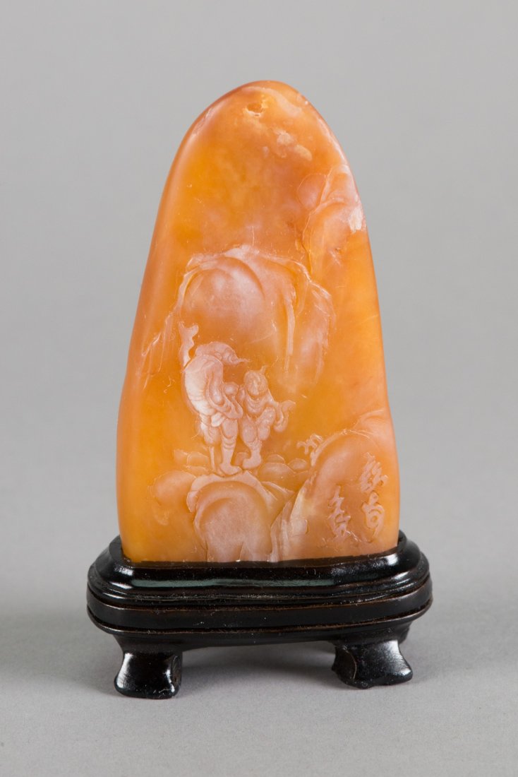Chinese Shoushan Stone Carved Boulder with Stand: Chinese Shoushan stone carved boulder; featuring landscape scene and script mark in relief; of light apricot tone; H: 10.5 cm, W: 6 cm, 166 grams