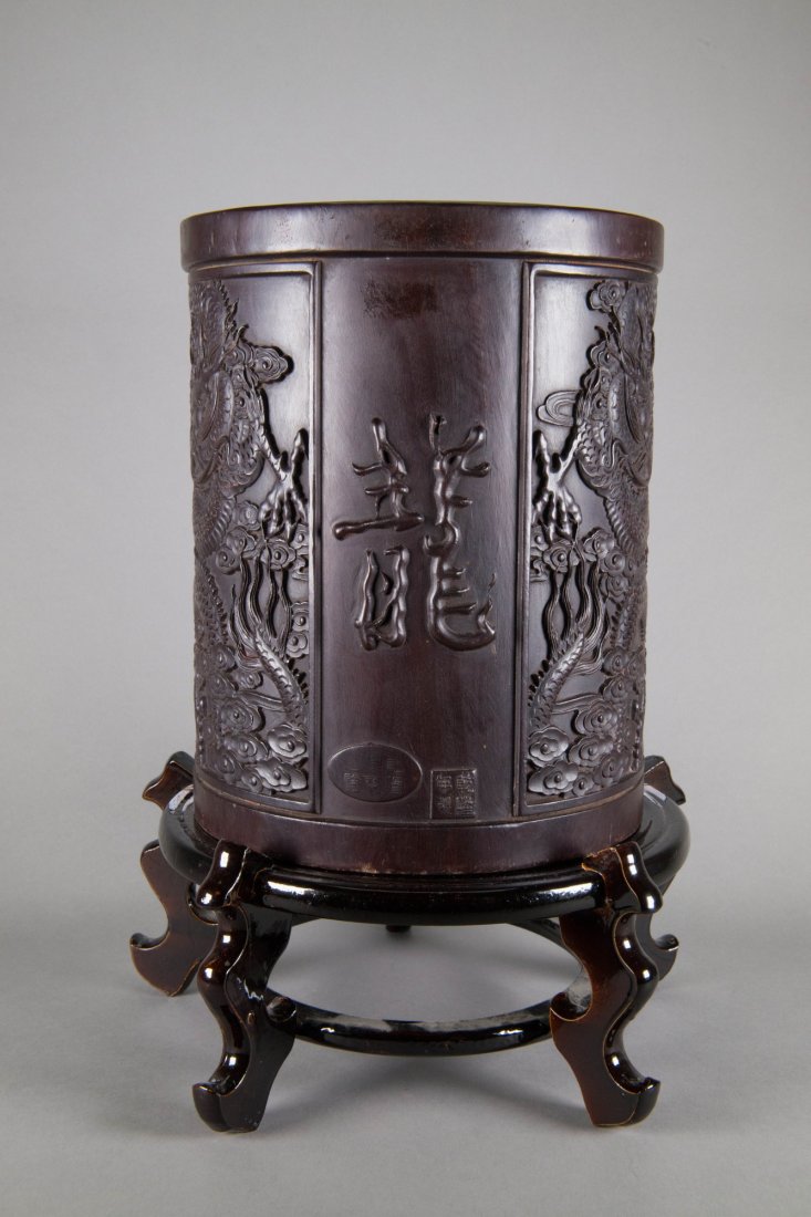 Chinese Zitan Bi Tong Brush Pot Qianlong Stand: Chinese Zitan Bi Tong brush pot; of cylindrical body; decorated outside with carved royal dragon pattern; with Qianlong Mark on body; wood stand included; H: 28.5cm, D: 23cm, 8 kg (without stand)_x000