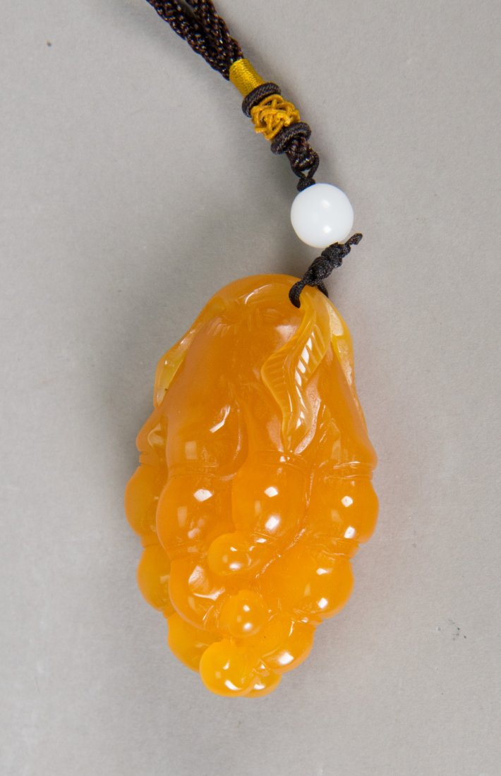 Indonesian Tianhuang Carved Pendant: Indonesian Tianhuang stone carved pendant; featuring grapes; of honey tone; pierced for suspension; H: 7 cm, W: 4 cm, 80 grams