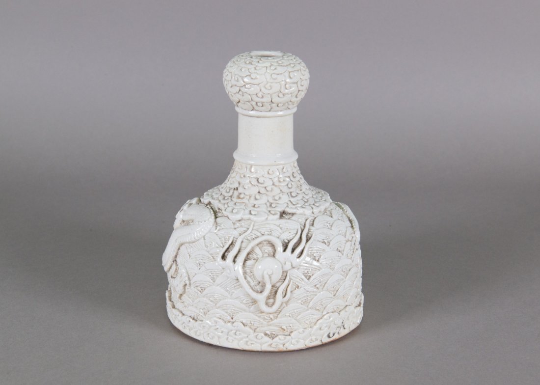 Chinese Porcelain Carved Dragon Vase Wang Bingrong: Chinese white porcelain carved dragon vase; of mallet shape with garlic form opening; featuring low-relief dragon and waves; four-character Wang Bingrong mark on base; H: 17 cm, D: 12 cm, 1 kg