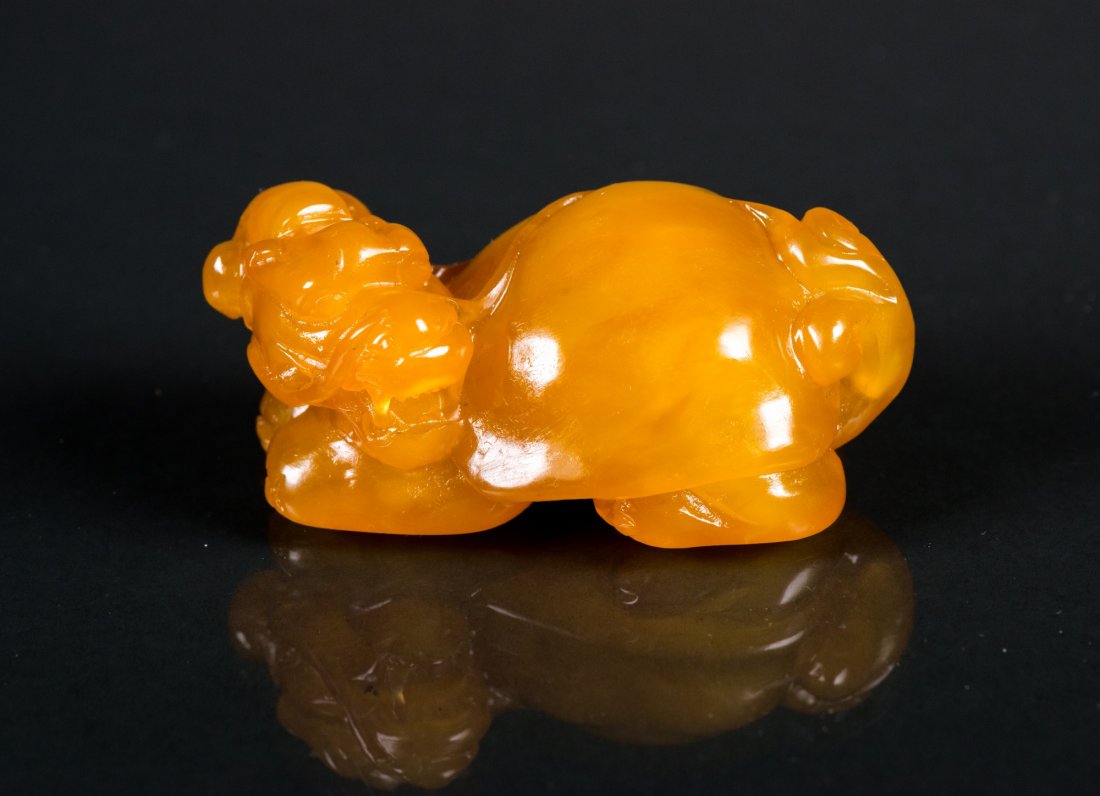 Indonesian Fine Tianhuang Stone Carved Pixiu: Indonesian fine Tianhuang stone carved Pixiu figure; featuring a Pixiu sitting on the ground with its head turning to the back; of honey yellow tone; H: 4.5 cm, W: 8 cm, 140 grams