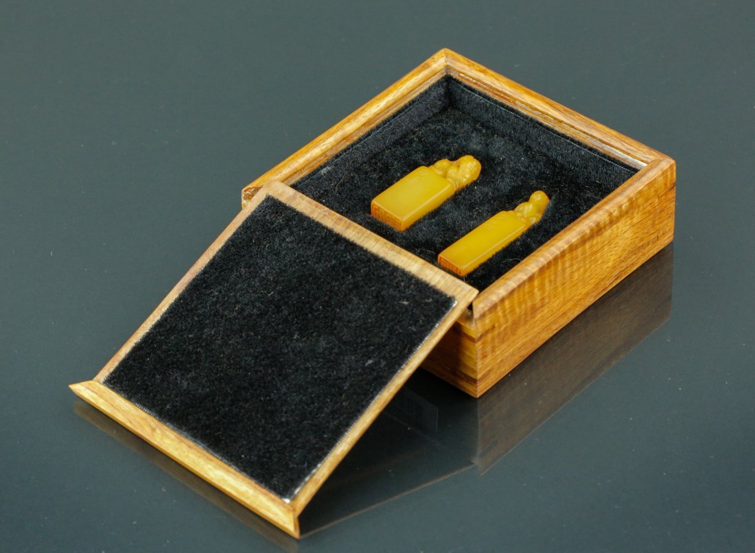 Pair of Chinese Shoushan Dragon Seal w/ Case: Pair of Chinese Shoushan seals; of square form; surmounted with Chilong; of honey yellow tone; carved base; custom made wood box included; H: 5 cm, W: 1 cm, 36 grams both