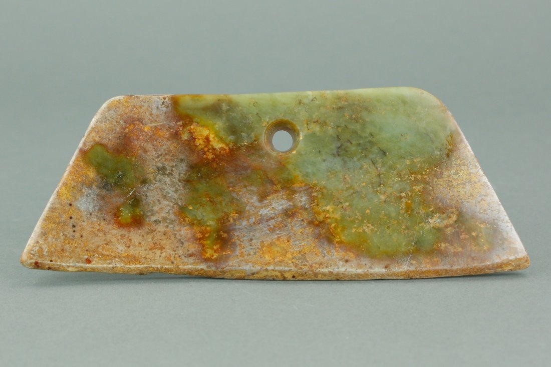 Archaic Jade Carved Axe Blade: Chinese archaic jade carved axe blade pendant; pierced for bounding handle; of green tone with russet surface alternation; possibly 2000 years old; L; 20 cm, W: 9 cm 335 grams