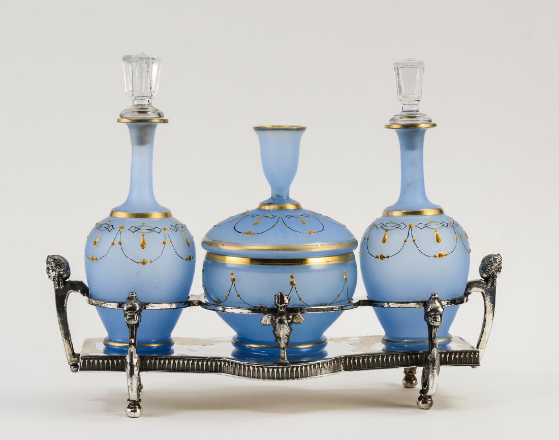 Meriden Britannia Silver Plate Dresser Set: Antique American Silverplate Dresser Set with Two Bristol Glass Perfume Bottles and Powder jar. Figural Silverplate base with some plate loss, and bending. Glass stoppers are replacements, otherwise,