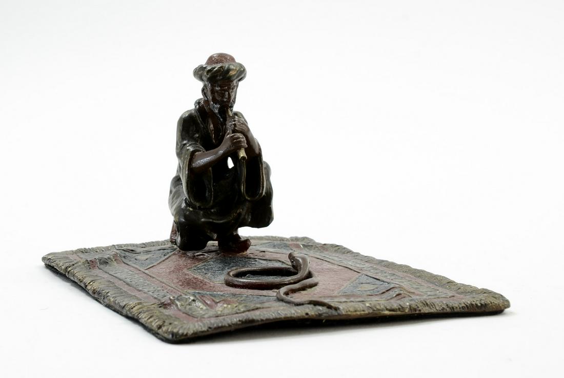 Vienna Bronze Snake Charmer: Cold Painted Austrian Bronze Figure of a snake charmer on Oriental Rug. Unsigned, good paint, likely a later casting. 3.5" x 6" x 5". Overall very good. Felt affixed to bottom. Manner of Franz Bergman