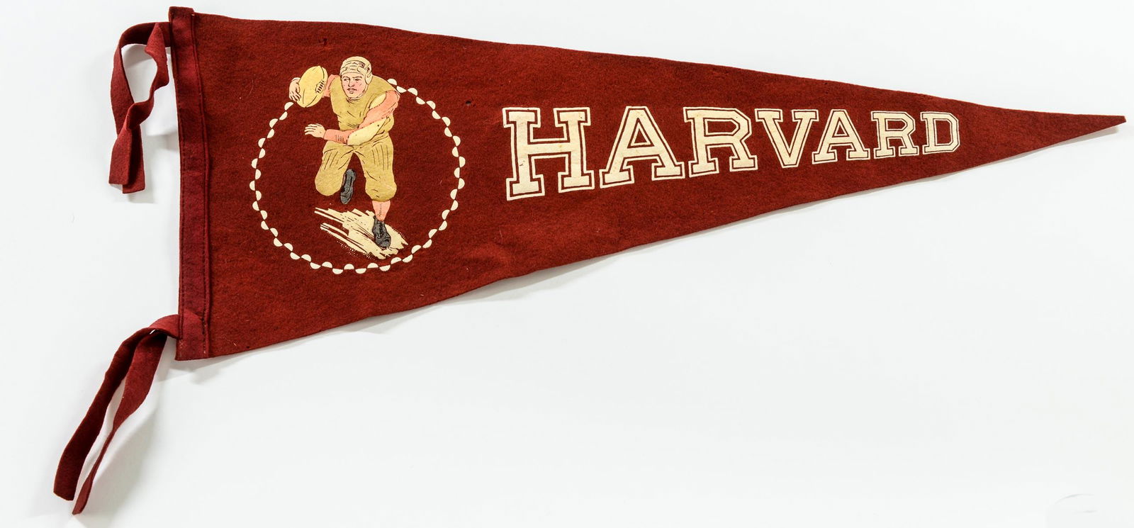 Harvard Football Felt Wool Pennant: Transfer Decorated Felt Wool Pennant for Harvard University Football, Circa 1910's-1920's With Henry Schwartz New York Label. 24" x 10" one moth hole in field, tip with tiny clip. strong graphics, ver