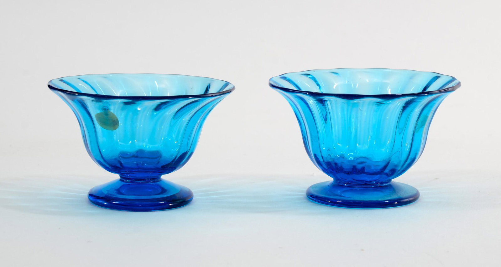 Steuben Two Celeste Blue Glass Open Salts: Sometimes referred to as nut dishes. Hand blown, ribbed body, polished pontils, each unmarked. 1.5" x 2.25" excellent condition. Keywords: Frederick Carder, Art Glass, Salt Cellar, Salt Dip