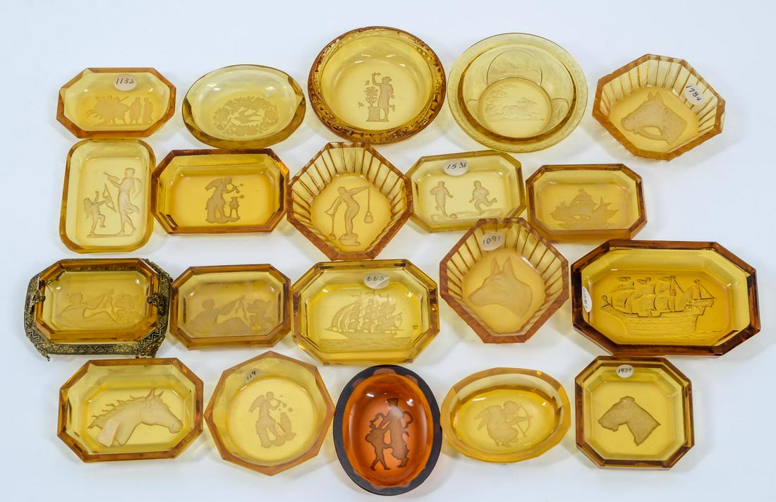 20 Amber Intaglio Glass Open Salts: Twenty amber Intaglio cut glass open salts. One in gilt metal frame. Subjects include: Classical, dog head, horse heads, stag, soccer, Cherub and ships. All appear to be in good condition, minor chips