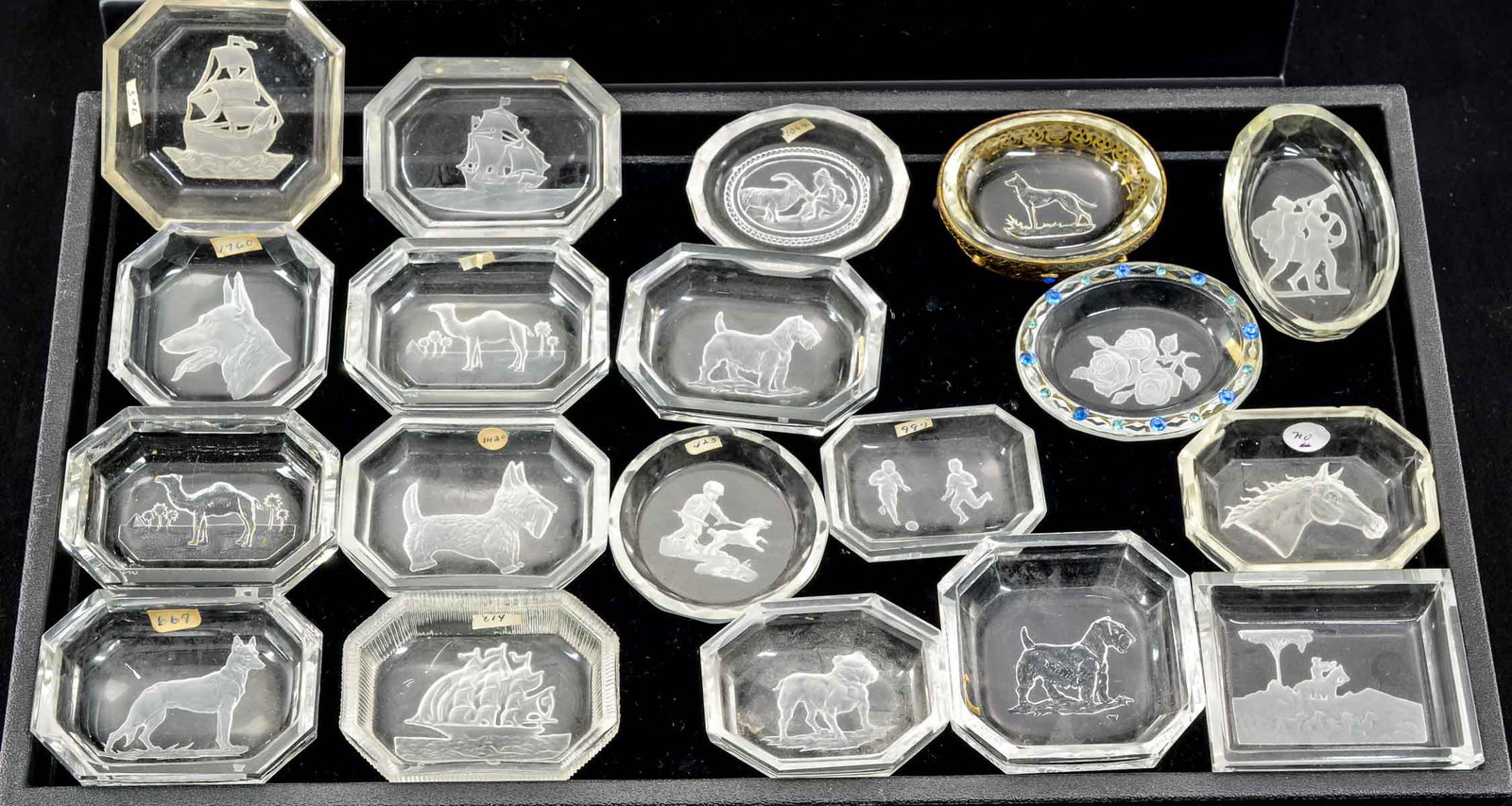 19 Clear Intaglio Glass Open Salts: Nineteen clear intaglio cut glass open salts. One dog intaglio set in gilt 'jeweled' frame. Subjects include: Dogs, camels, ships, horses, hunting, Classical and floral. All appear to be in good condi