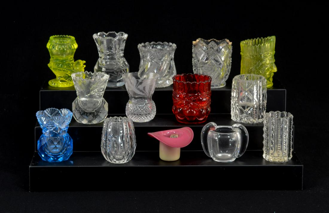 14 Colored Pattern Glass Toothpick Holders: Fourteen colored and clear pattern glass toothpick holders. Including Pairpoint Burmese hat shape (paper label), vaseline bird form, Vaseline Indian head, light blue and a ruby, the remaining are clea