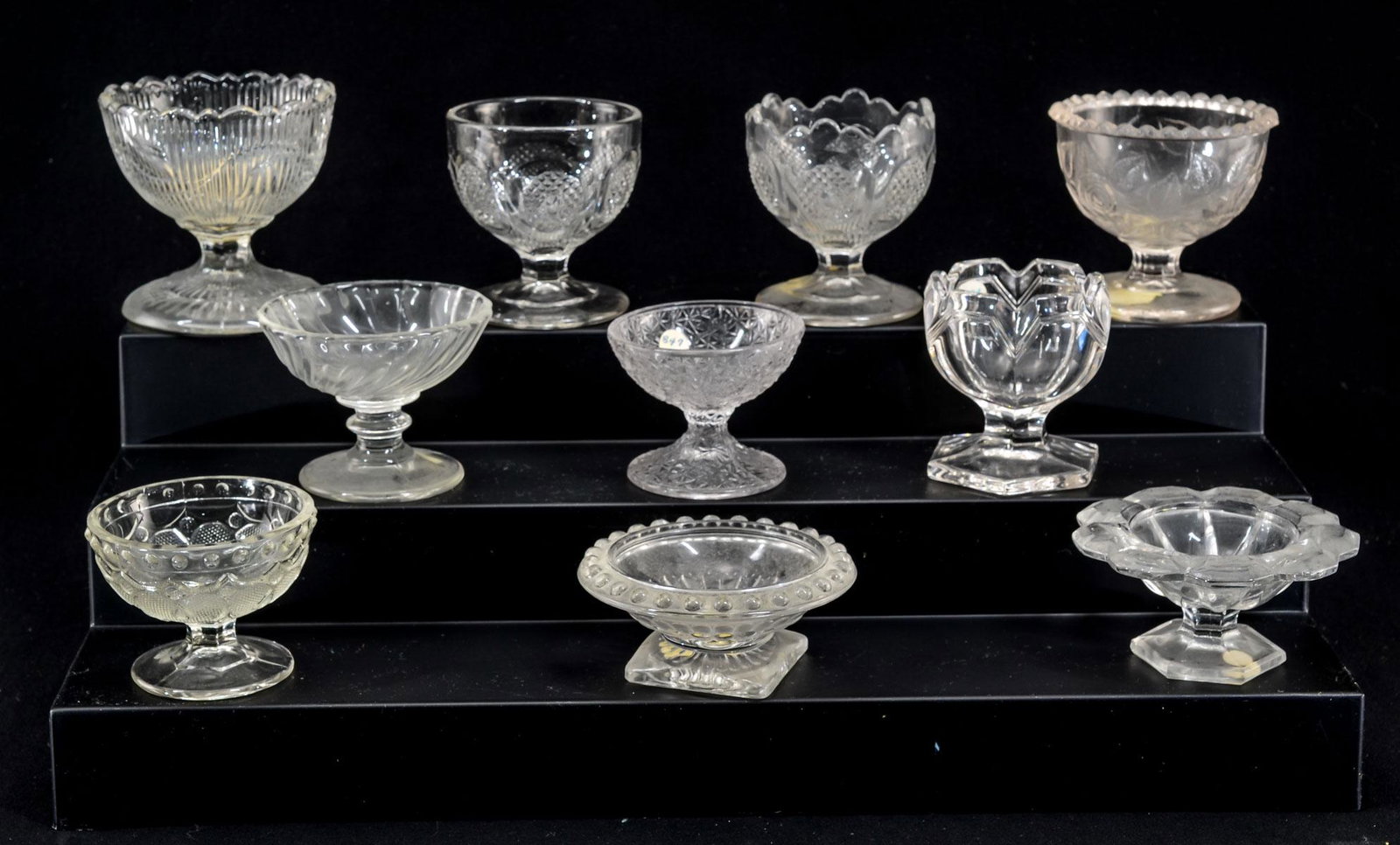 10 Pattern Glass Pedestal Open Salts: Ten clear pressed pattern glass pedestal open salts. Various patterns. Late 19th century. All appear to be in good condition, some rim nicks, contact marks etc. Keywords: Salt Cellar, Salt Dip, EAPG, 