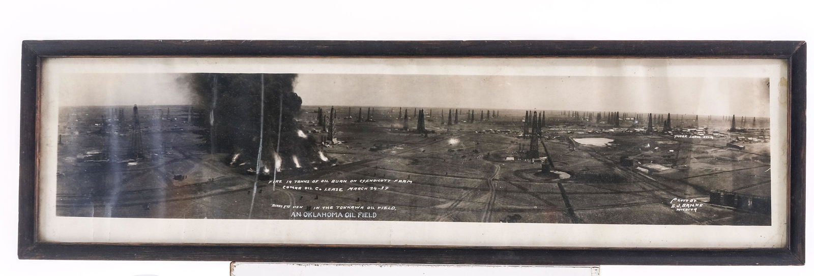 Oil Field Fire Yardlong Photograph: Photo of the Oklahoma oil field fire 14 tanks of oil burn on C.C.Endicott Farm. Comar Oil Co. Lease March 24-29. Framed under glass, not inspected out of frame. 32" X 9" image by eye 30 12" X 7 1/2".