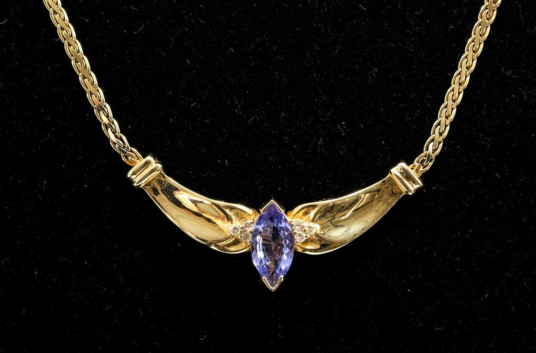 14K Yellow Gold Tanzanite and Diamond Necklace: 14 karat yellow gold necklace with a pendant including a central marquise cut Tanzanite and 6 small round brilliant cut diamonds. Marked 14K, necklace chain marked "GG", pendant marked "BJC". Lobster 