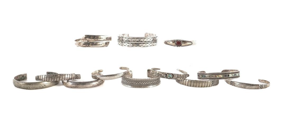 12 Silver Tribal Cuff Bracelets: Collection of cuffs of varying styles. XRF tested to determine composition and purity of metal. Seven in sterling silver. Four comprised mainly of silver (1 of which features a rhodolite cabochon and