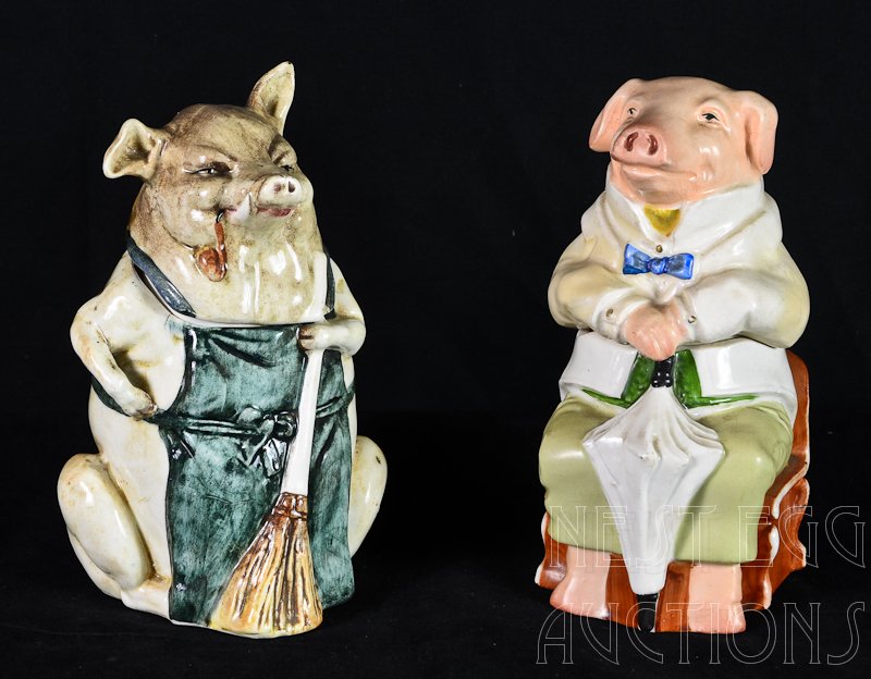 Two Majolica Figural Pig Tobacco Humidors: One with Broom, 7" Tall, impressed mark 4512, 92, underglaze line at rim, the other: with umbrella 6.75" Tall, unmarked. See Victorian Humidors by Joseph Horowitz Pg 147 #657 and pg 149 #665