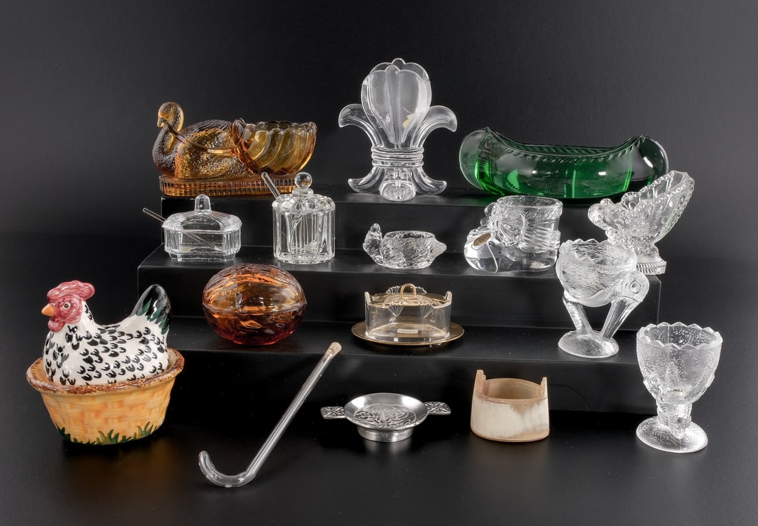 16 Novelty Salts, etc: This group includes egg cups, toothpick holders, small covered vessels(mustard dishes). Souvenir canoe, French crystal bootie, an amber covered walnut, a carved horn bucket , a clear glass cane with s