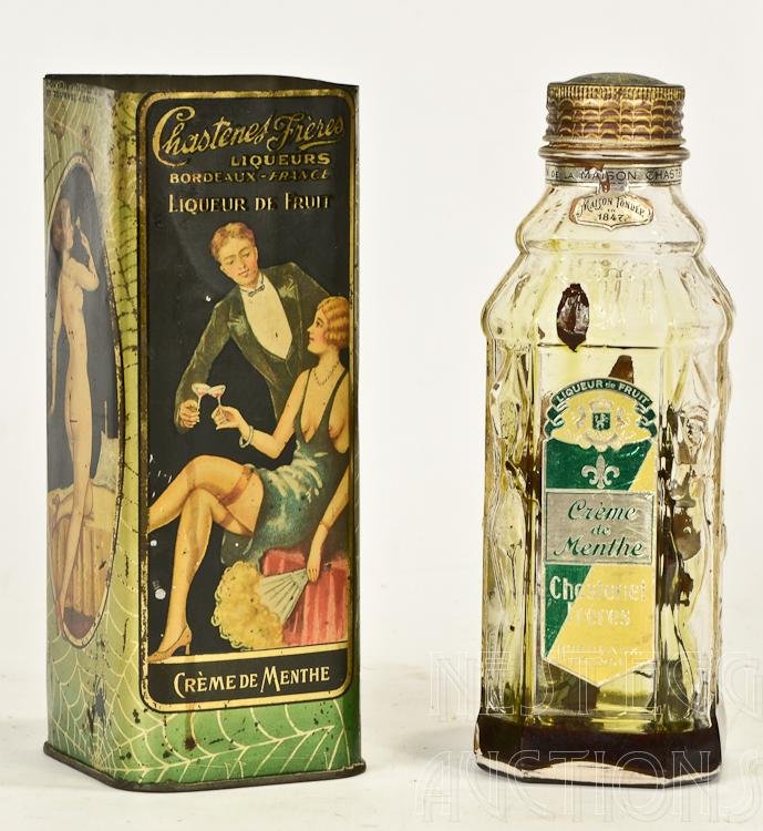 Chastenet Freres, Bordeaux France Bottle: Creme De Menthe, Early 20th Century, With original Lithographed tin sleeve with Nudes, and Spiderwebs, Bottle Is molded with figural nudes. Cap is seized, Contents of herbs and old liquid inside. Top 