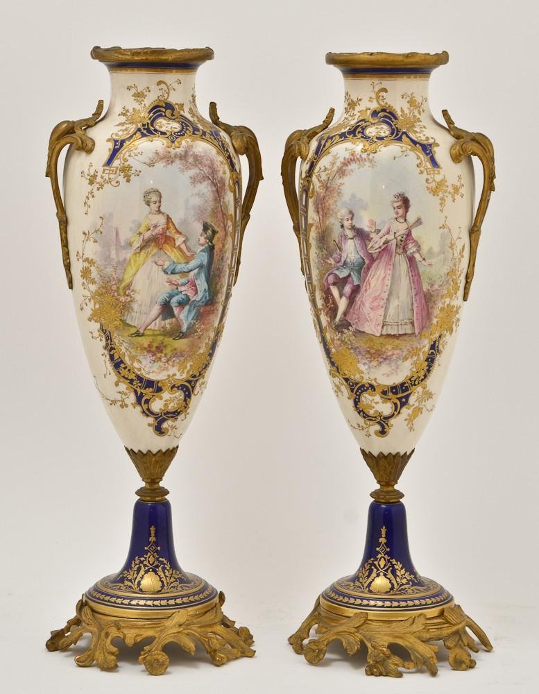 Sevres Style Gilt Bronze mounted porcelain vases: Most likely French, 19th Century. This pair of garnitures / urns stands 18.5" Tall, with gilt bronze mounts in the Rococo fashion. Very fine handpainted underglaze scenes on both the front and ba