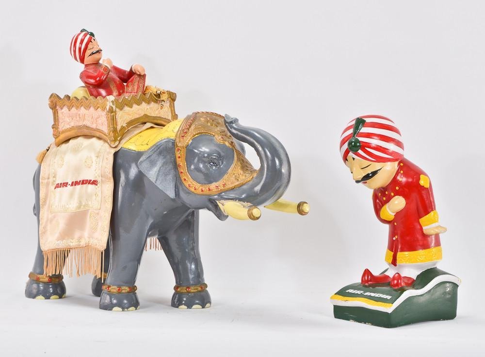 Two Vintage Air India Advertising figurines: Both painted composition, bearing Bandivdekar paper labels. A bowing man in turban in very good condition stands 12" tall, and a man riding an elephant 16" x 16". Elephant has cracks in