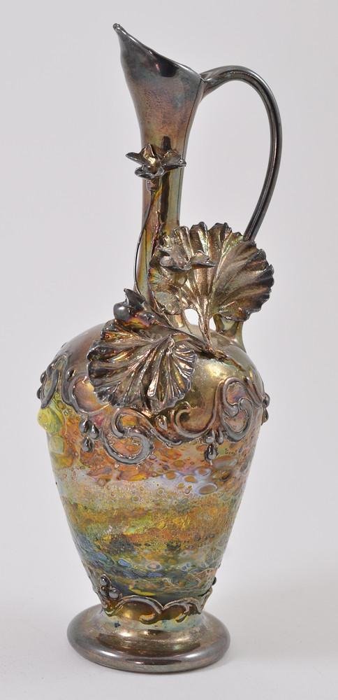 Silver overlay cypriote art glass ewer: Manner of Tiffany and Loetz. Unmarked and unsigned. handblown glass, excellent condition. fine silver overlay, no damage, repairs, or chips. Stands 7.75" tall.