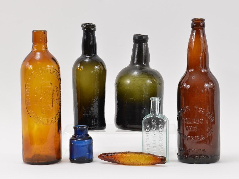 Group of 7 American Glass Bottles: Includes an amber Duffy Malt Whiskey Company Rochester NY, good condition, 10.5" tall, A green unmarked hand blown beer bottle with pontil mark and appled top, good condition, 8.75" tall, a 