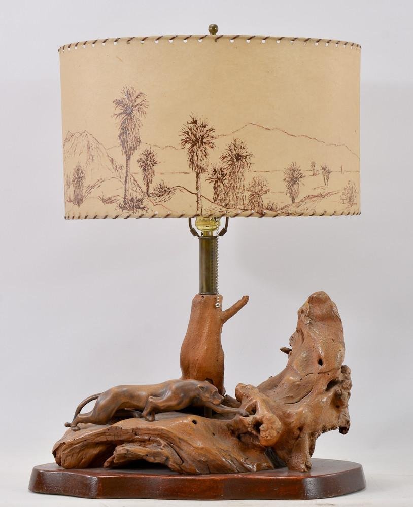 Carved Driftwood Panther Lamp: The Table lamp of polished and carved driftwood with an integrated panther or mountain lion stalking it's prey. Hand painted and signed shade with an American desert theme. 20th Century. 24" tall