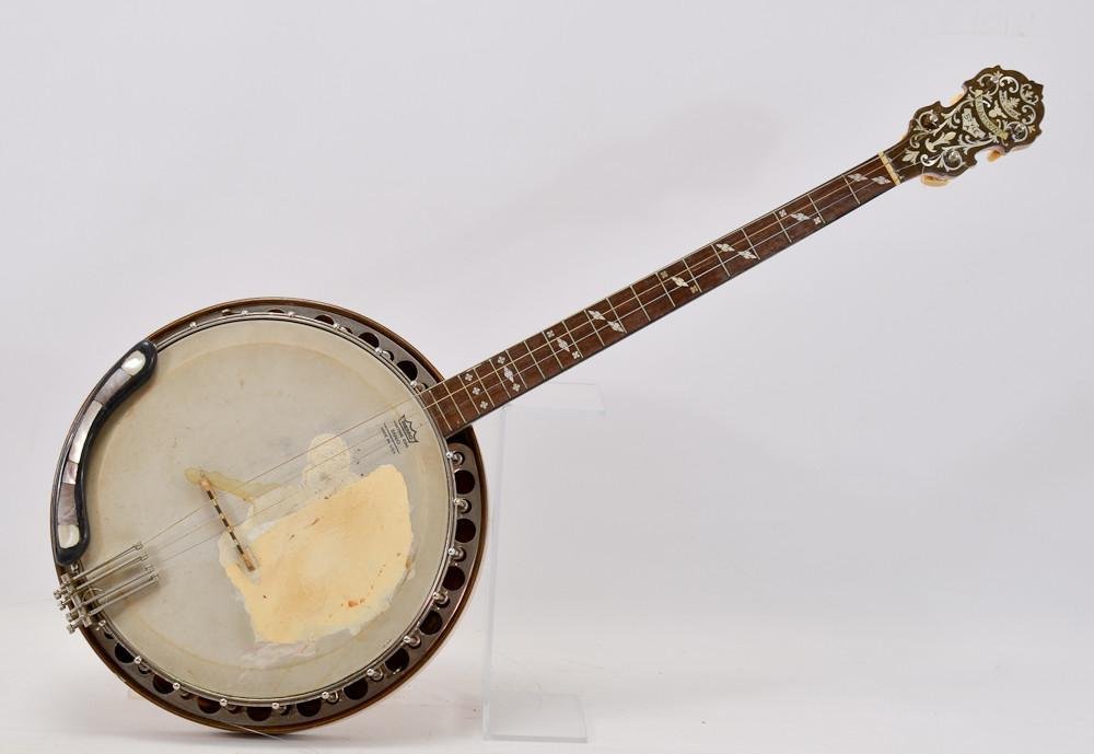 W.M. Lange Paramount Style A Tenor Banjo: The second of two in this auction. Good inlay, wear from regular play. Sticker to back of resonator, Straight neck, serial number 8385. 33" x 13" original case as-is.