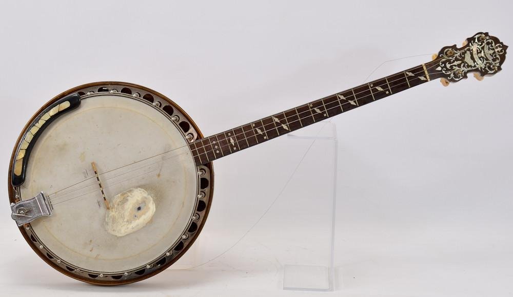 W.M. Lange Paramount Style A Tenor Banjo: Good solid condition, but plenty of playwear from normal use. some loss to head stock inlay, serial number 1552, Gretsch bridge, straight neck. 33" x 13" original case.