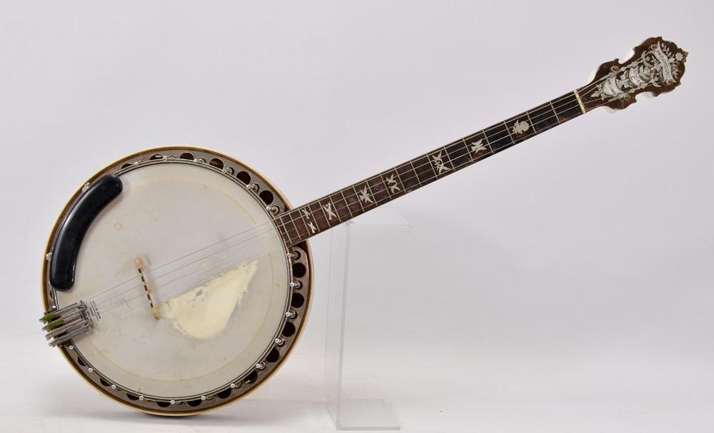 W.M. Lange Paramount Style C Tenor Banjo: With extensive Mother of Pearl inlay including dove fretboard inlay, carved neck heel, inlaid body and resonator. 35" x 15" Serial Number 1469. Some play wear, possible fretboard repairs.&nb